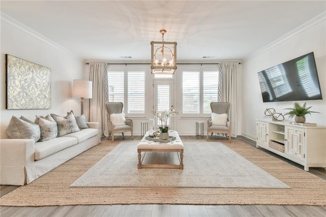 living room featuring a chandelier, ornamental molding, and wood finished floors