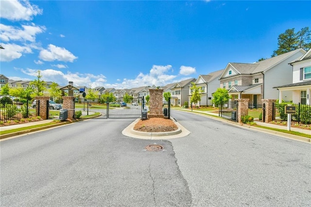 view of road with a gate, a residential view, and sidewalks