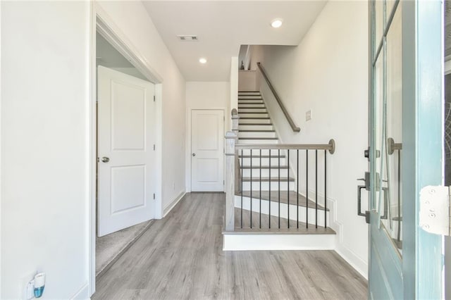 entryway featuring stairs, baseboards, visible vents, and wood finished floors
