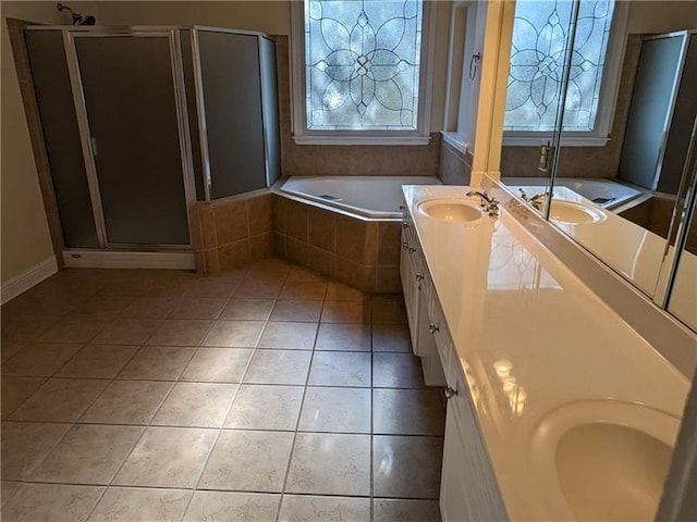 full bath featuring double vanity, tile patterned floors, a sink, and a healthy amount of sunlight