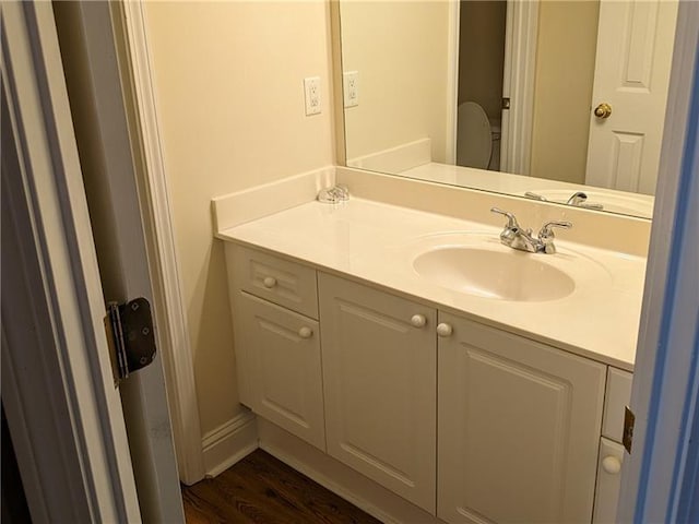 bathroom with vanity, toilet, and wood finished floors