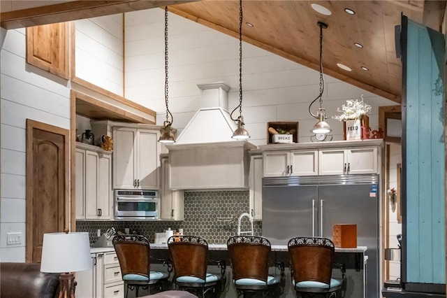 kitchen featuring stainless steel appliances, tasteful backsplash, high vaulted ceiling, decorative light fixtures, and white cabinets