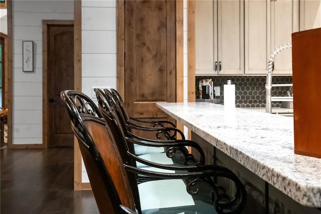 bar featuring tasteful backsplash and light stone countertops