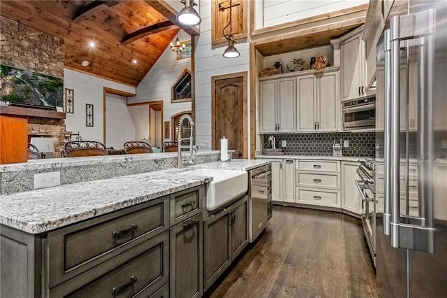 kitchen with light stone counters, sink, wooden ceiling, dark hardwood / wood-style floors, and wood walls