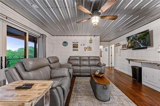 living room with wooden walls, wood ceiling, and dark hardwood / wood-style floors