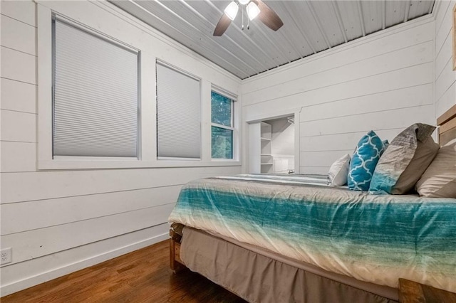 bedroom featuring ceiling fan, wood walls, dark hardwood / wood-style flooring, and wood ceiling