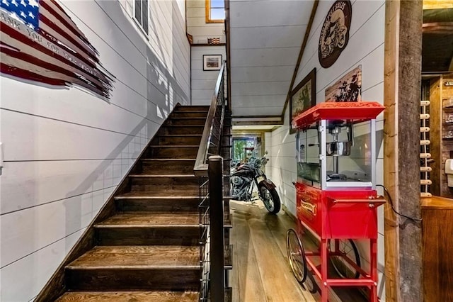 stairs featuring hardwood / wood-style flooring and wood walls