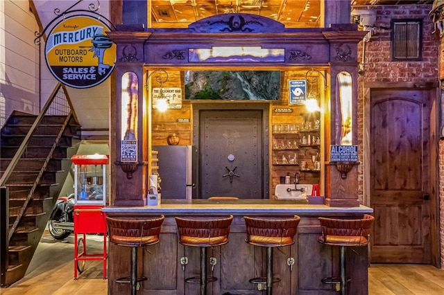 bar with wooden walls and wood-type flooring