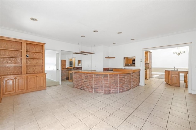 kitchen featuring light tile patterned floors, a kitchen island, light countertops, and crown molding