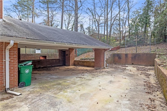 view of patio / terrace with a carport, fence, and driveway