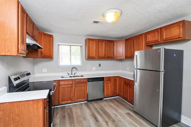 2222 Mcafee Rd, Decatur, GA 30032 - kitchen with sink, light hardwood / wood-style flooring, a textured ceiling, and appliances with stainless steel finishes