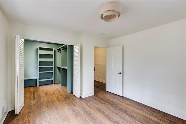 unfurnished bedroom with hardwood / wood-style floors and a closet