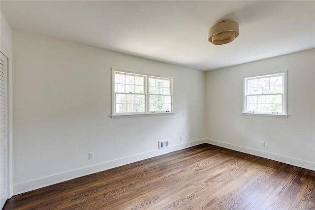 spare room featuring dark wood-type flooring