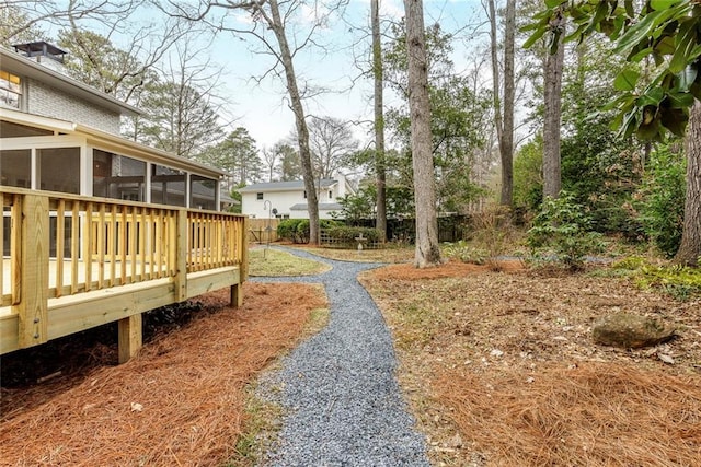 view of yard featuring a wooden deck and a sunroom