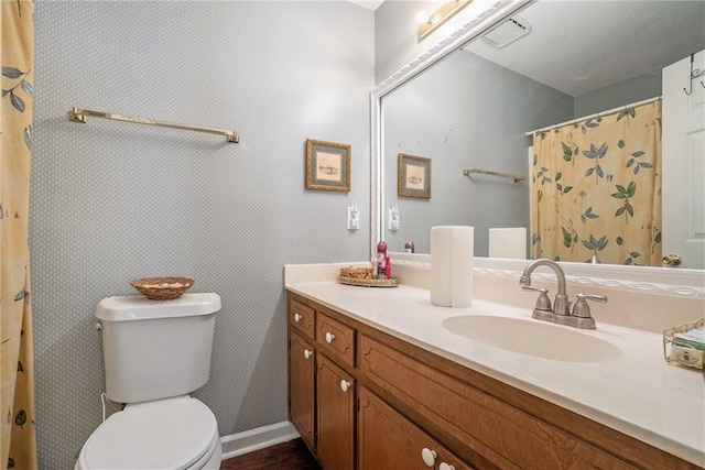 bathroom with curtained shower, vanity, and toilet