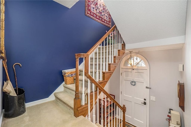 carpeted entrance foyer featuring a textured ceiling