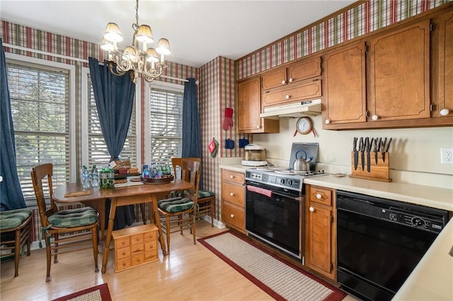 kitchen featuring black appliances, hanging light fixtures, a wealth of natural light, and an inviting chandelier