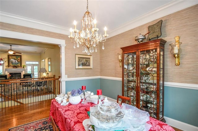 1173 Saint Charles Pl, Gainesville, GA 30501 - dining area featuring ceiling fan, crown molding, wood finished floors, a fireplace, and a chandelier
