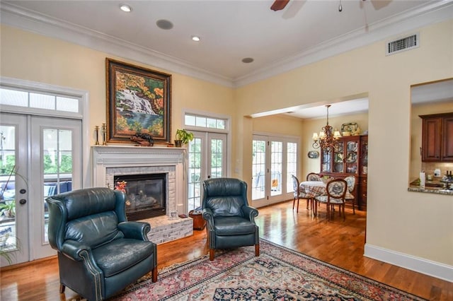 1173 Saint Charles Pl, Gainesville, GA 30501 - living area with french doors, ornamental molding, a fireplace, wood finished floors, and recessed lighting