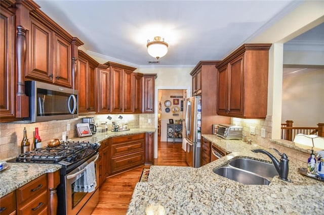 1173 Saint Charles Pl, Gainesville, GA 30501 - kitchen featuring stainless steel appliances, wood finished floors, decorative backsplash, ornamental molding, and light stone counters