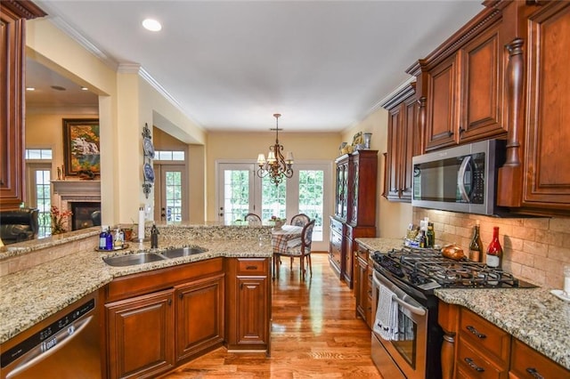1173 Saint Charles Pl, Gainesville, GA 30501 - kitchen with stainless steel appliances, healthy amount of natural light, light wood finished floors, a chandelier, and crown molding