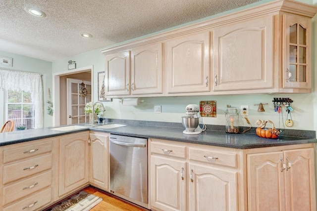 kitchen with kitchen peninsula, sink, a textured ceiling, light brown cabinets, and stainless steel dishwasher