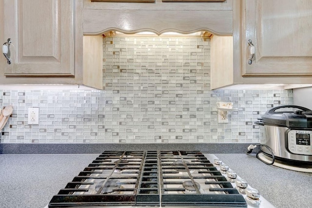 kitchen featuring cooktop, light brown cabinets, and decorative backsplash