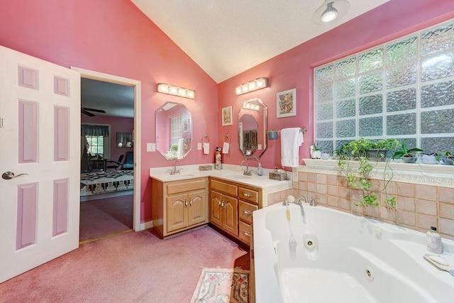 bathroom featuring a textured ceiling, lofted ceiling, a bath, and vanity