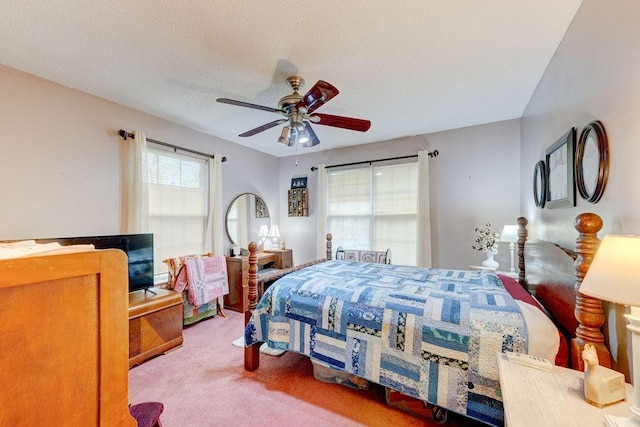 bedroom with ceiling fan, carpet flooring, and a textured ceiling