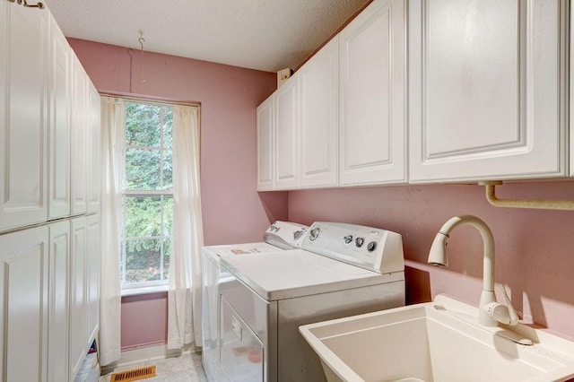 laundry room featuring sink, separate washer and dryer, cabinets, and a textured ceiling