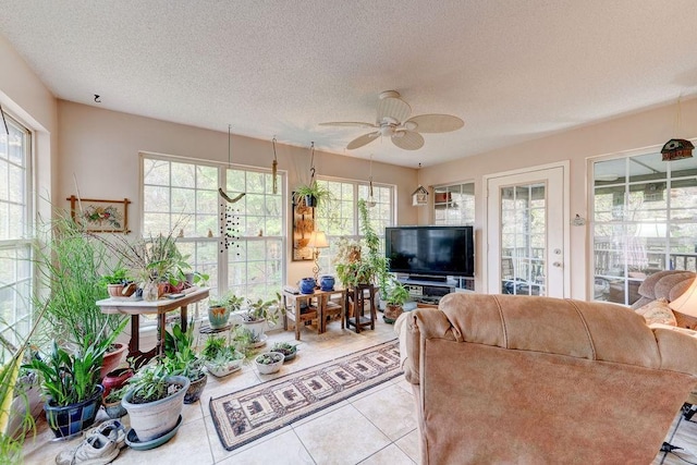 tiled living room featuring ceiling fan and a textured ceiling