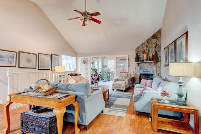 living room featuring a fireplace, ceiling fan, high vaulted ceiling, and light hardwood / wood-style floors