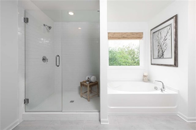 bathroom with tile patterned floors and independent shower and bath