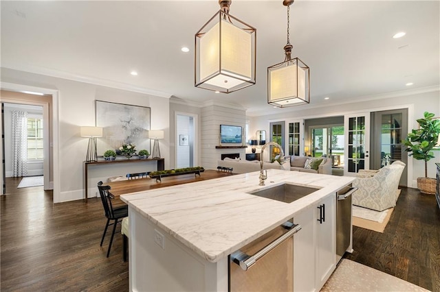 kitchen featuring a sink, plenty of natural light, light stone counters, white cabinetry, and recessed lighting
