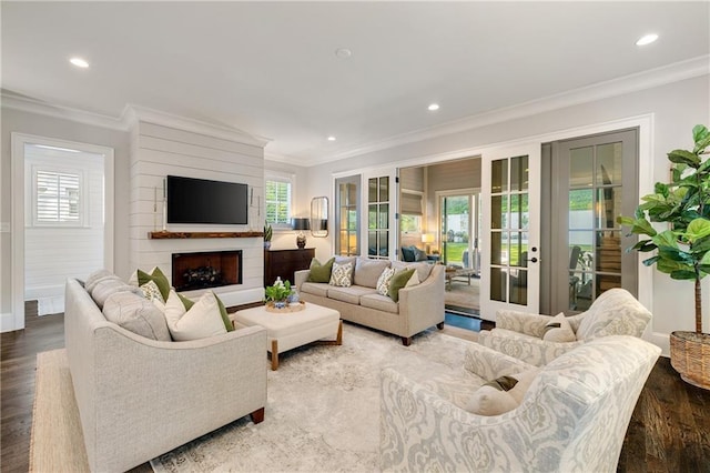 living area featuring a large fireplace, wood finished floors, crown molding, french doors, and recessed lighting