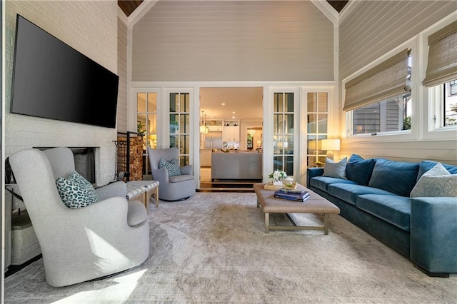 living room with a fireplace and a towering ceiling
