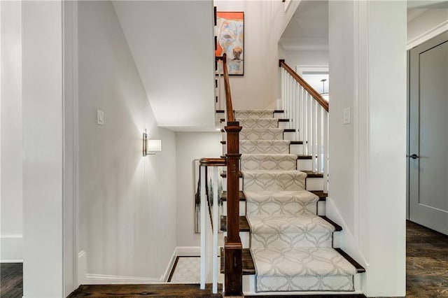 stairway featuring wood finished floors and baseboards