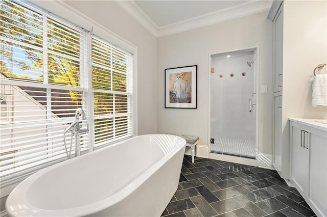 bathroom with a stall shower, crown molding, a soaking tub, vanity, and baseboards
