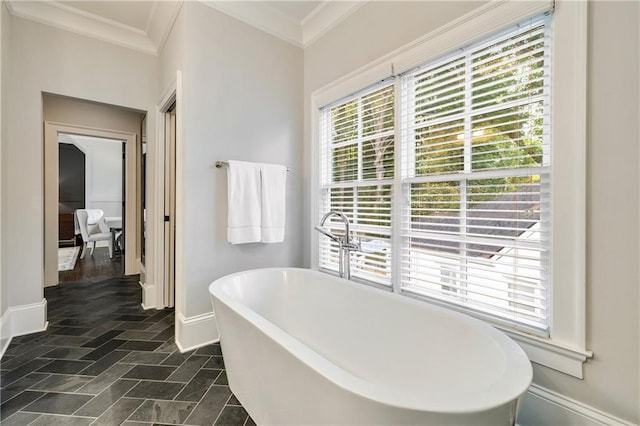 full bath with crown molding, baseboards, and a freestanding tub
