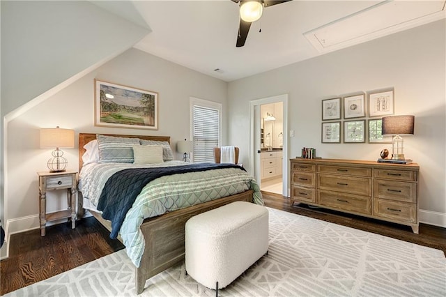 bedroom with attic access, wood finished floors, ensuite bathroom, baseboards, and a ceiling fan