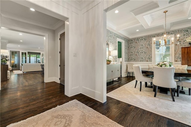 dining room with ornamental molding, a chandelier, wood finished floors, a decorative wall, and wainscoting