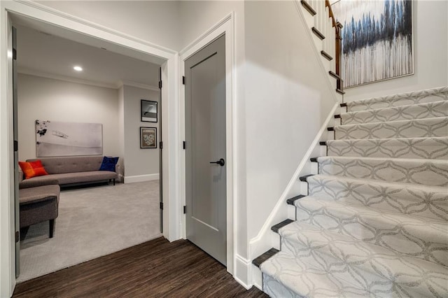 stairs featuring wood finished floors, crown molding, baseboards, and recessed lighting