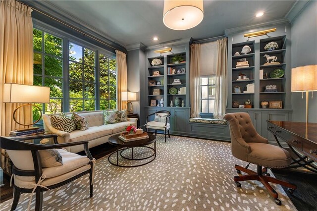 sitting room with crown molding, healthy amount of natural light, built in features, and carpet flooring