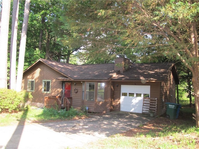 view of front of home with driveway, an attached garage, a chimney, and a shingled roof