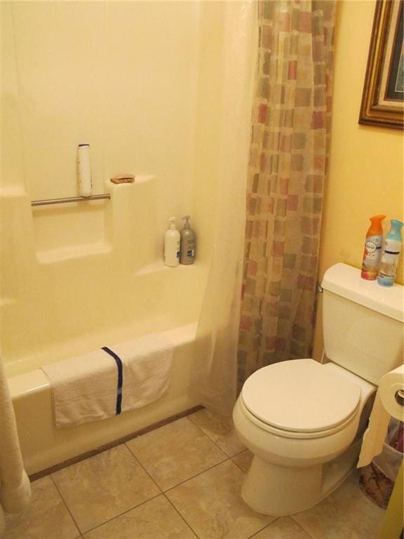 full bathroom with toilet, tile patterned flooring, and shower / tub combo