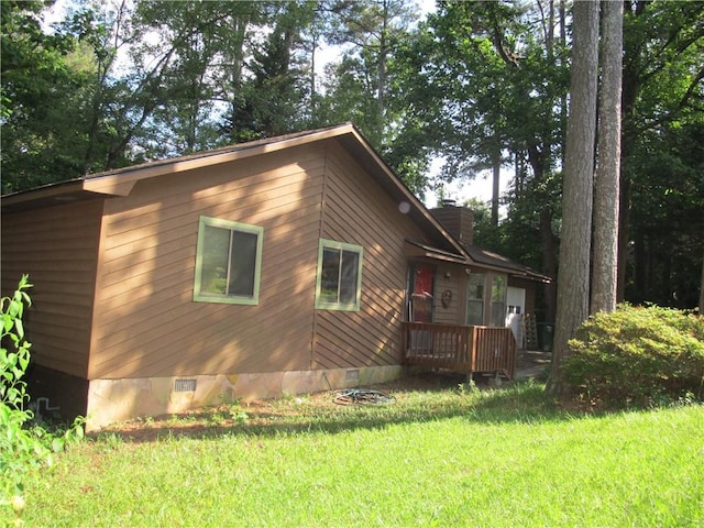 view of home's exterior featuring crawl space, a yard, and a chimney