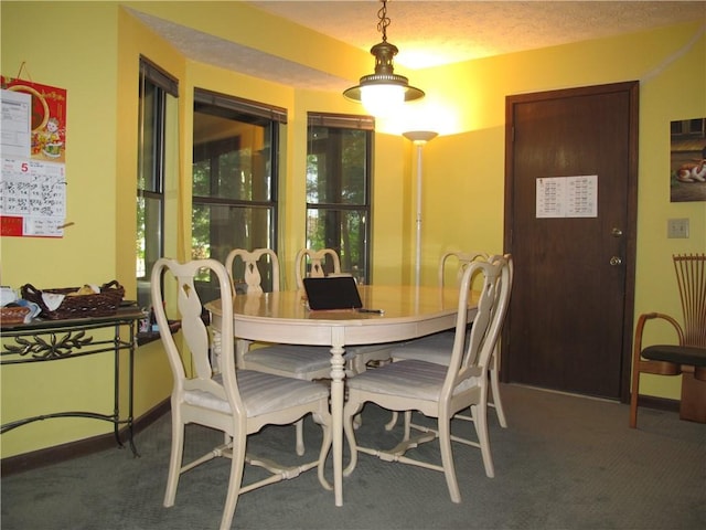 carpeted dining space featuring baseboards