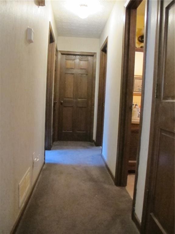 corridor with baseboards and carpet