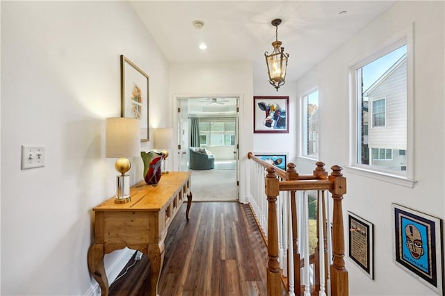 corridor featuring dark hardwood / wood-style flooring and an inviting chandelier