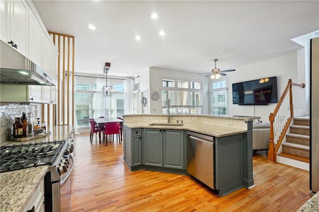 kitchen featuring a sink, appliances with stainless steel finishes, gray cabinets, and light wood-style flooring